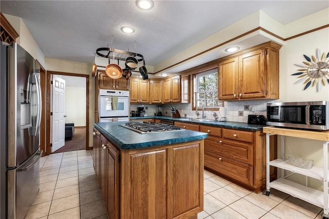 kitchen with sink, light tile patterned floors, backsplash, stainless steel appliances, and a center island