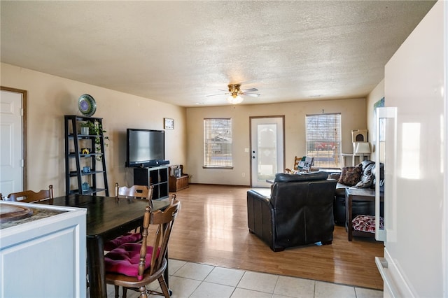 tiled living room featuring ceiling fan and a textured ceiling