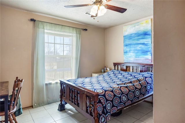 tiled bedroom with ceiling fan and a textured ceiling