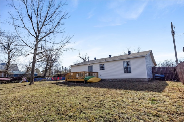 back of house featuring a wooden deck and a lawn