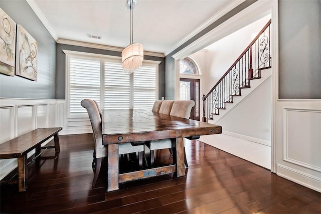 dining space featuring dark wood-type flooring and ornamental molding