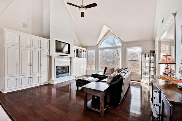 living room with ceiling fan, a premium fireplace, dark hardwood / wood-style flooring, and high vaulted ceiling