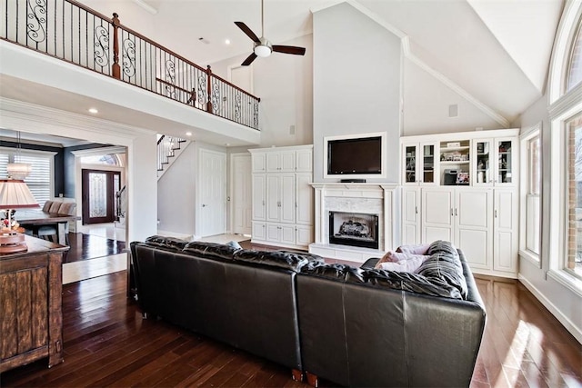 living room featuring ceiling fan, a premium fireplace, dark hardwood / wood-style flooring, and high vaulted ceiling