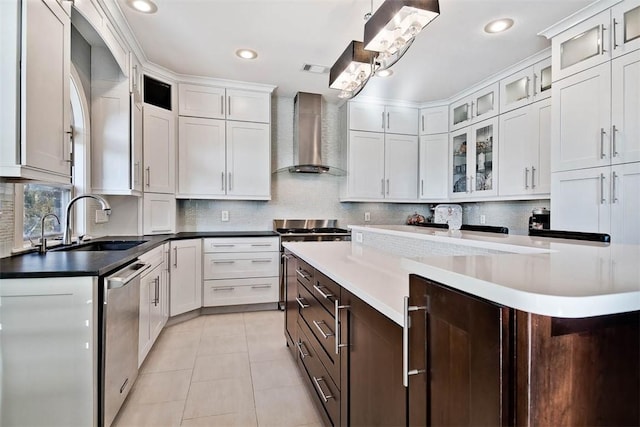 kitchen featuring stainless steel appliances, white cabinetry, pendant lighting, and wall chimney exhaust hood