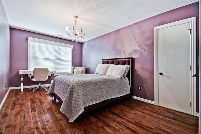 bedroom featuring a notable chandelier and dark wood-type flooring