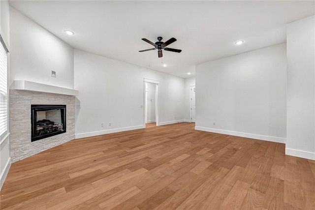 unfurnished living room featuring a fireplace, light hardwood / wood-style floors, and ceiling fan