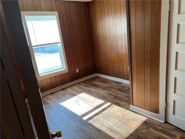 spare room with hardwood / wood-style flooring, plenty of natural light, and wood walls