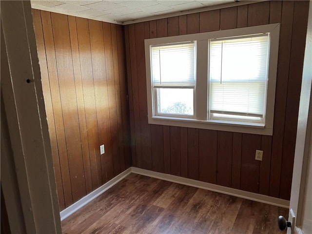 unfurnished room with hardwood / wood-style flooring and wood walls