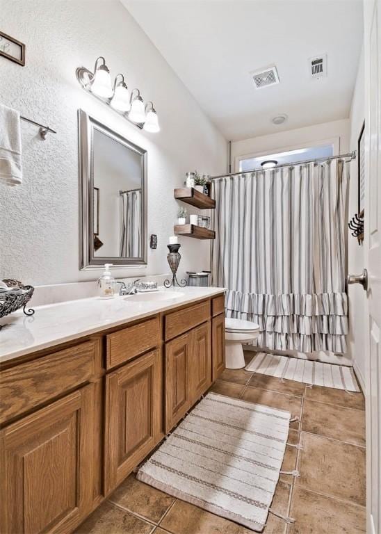 bathroom with tile patterned flooring, vanity, and toilet