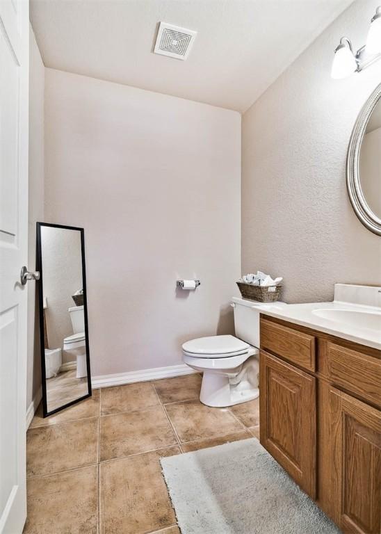 bathroom featuring vanity, tile patterned floors, and toilet