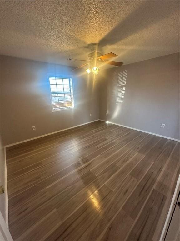 spare room with dark hardwood / wood-style flooring, a textured ceiling, and ceiling fan