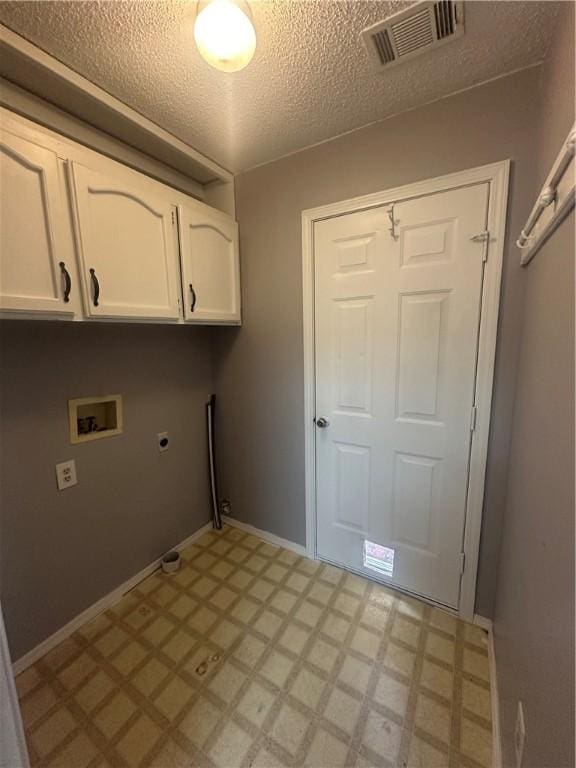 washroom with cabinets, hookup for a washing machine, a textured ceiling, and electric dryer hookup