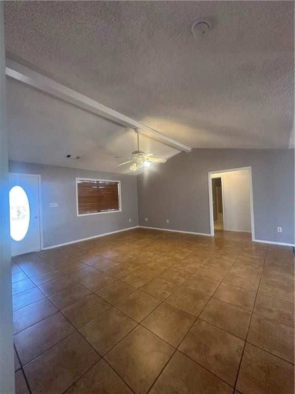 empty room featuring tile patterned flooring, a textured ceiling, lofted ceiling with beams, and ceiling fan