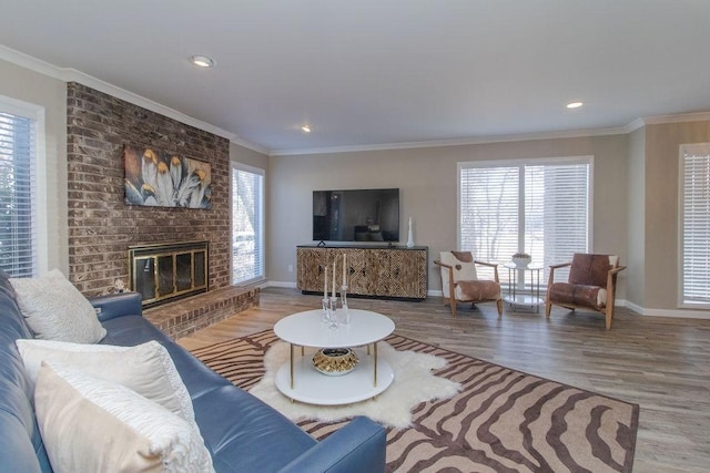 living room featuring a brick fireplace, crown molding, and hardwood / wood-style flooring