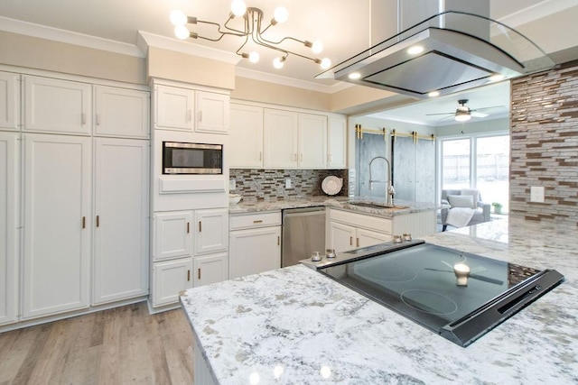 kitchen featuring appliances with stainless steel finishes, white cabinetry, light stone counters, ornamental molding, and kitchen peninsula