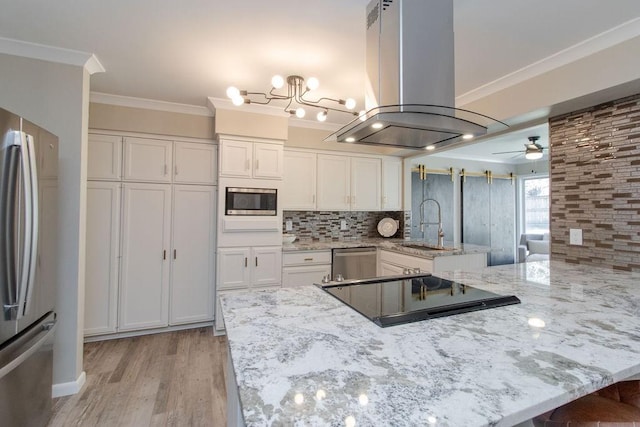 kitchen with island exhaust hood, appliances with stainless steel finishes, white cabinets, and kitchen peninsula