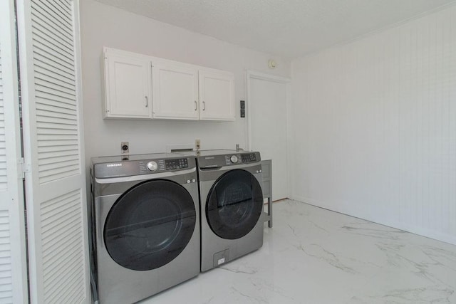 clothes washing area featuring independent washer and dryer and cabinets