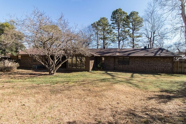 back of house featuring a lawn and central air condition unit