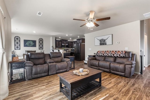 living room featuring ceiling fan and light wood-type flooring