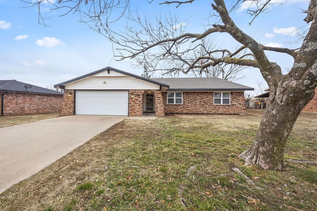 ranch-style home featuring a garage and a front yard