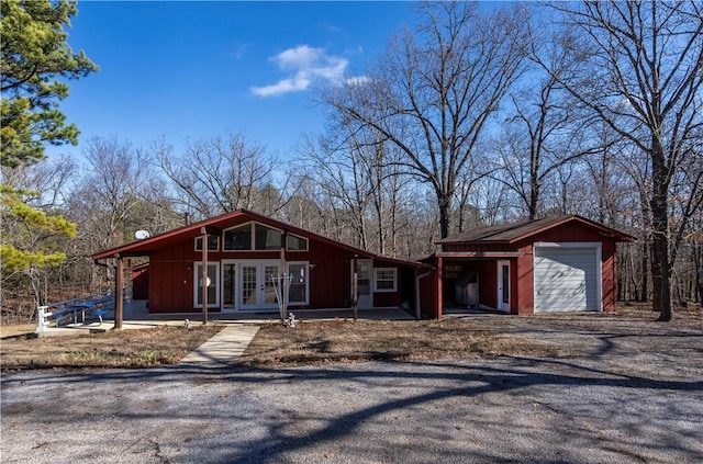 view of front of house featuring a garage, an outdoor structure, and french doors