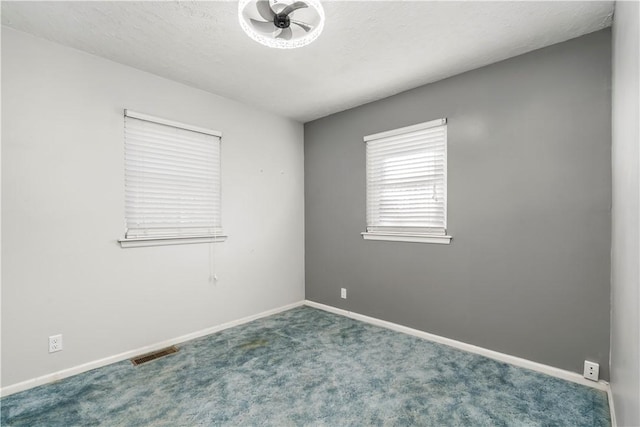 empty room with ceiling fan, carpet, and a textured ceiling