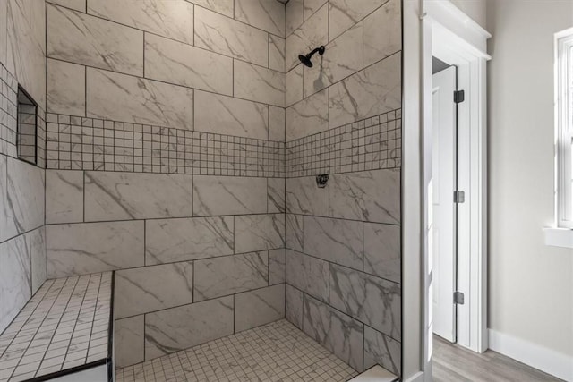 bathroom with hardwood / wood-style floors and tiled shower