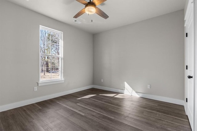 spare room with dark wood-type flooring and ceiling fan