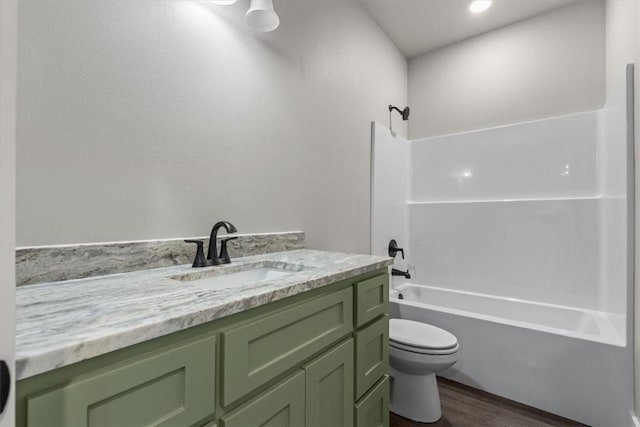 full bathroom with shower / bath combination, vanity, wood-type flooring, and toilet