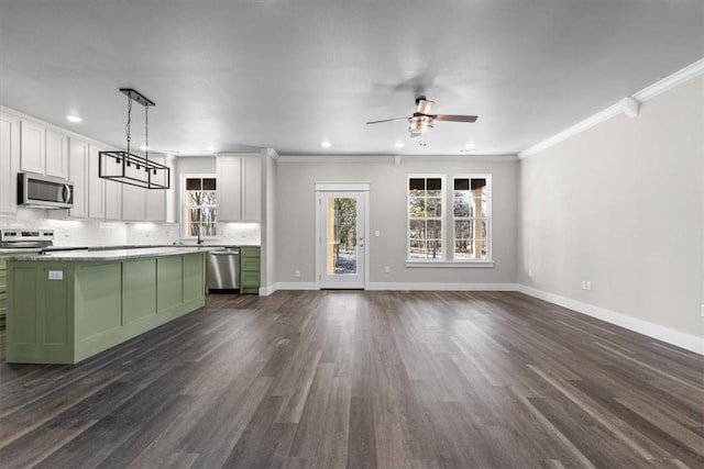 kitchen with appliances with stainless steel finishes, hanging light fixtures, tasteful backsplash, green cabinetry, and white cabinets