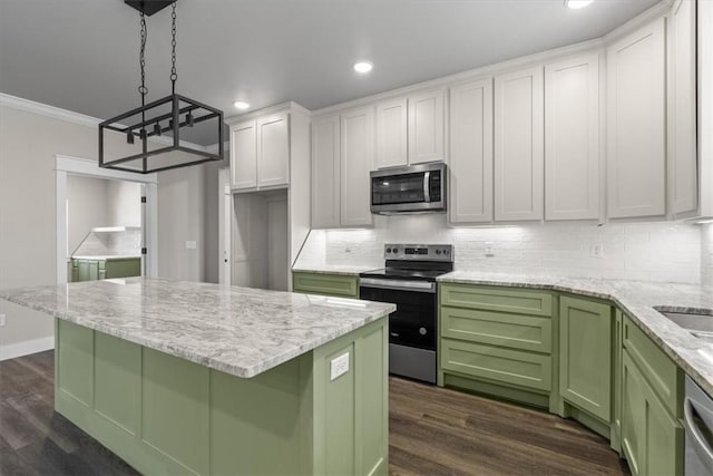 kitchen with pendant lighting, a kitchen island, white cabinets, and appliances with stainless steel finishes