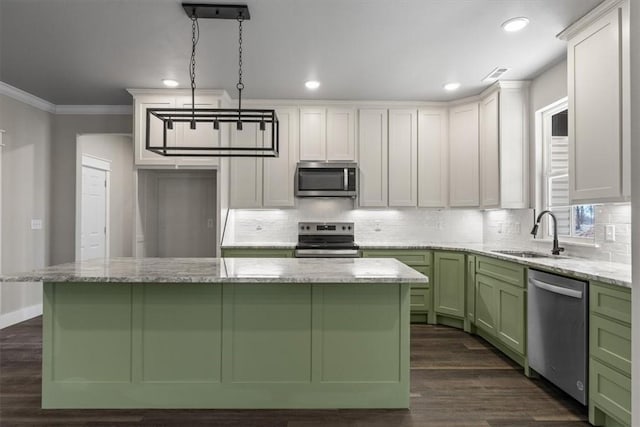 kitchen featuring stainless steel appliances, a kitchen island, sink, and decorative light fixtures