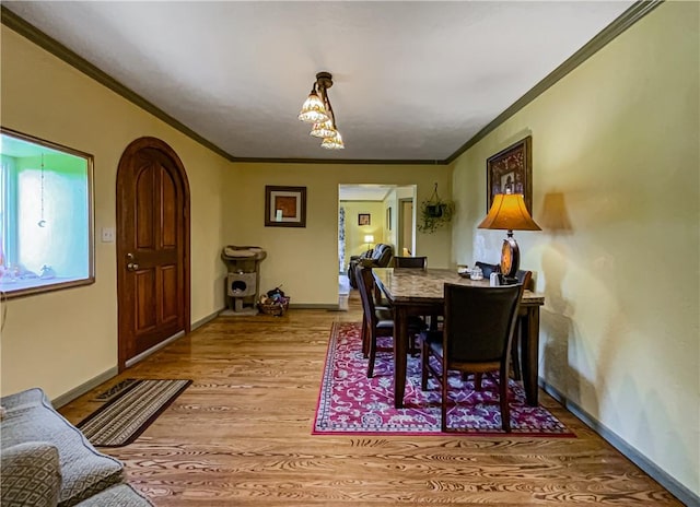 dining space featuring ornamental molding and light hardwood / wood-style flooring