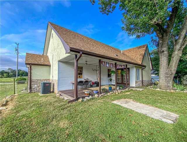 rear view of property with cooling unit and a lawn