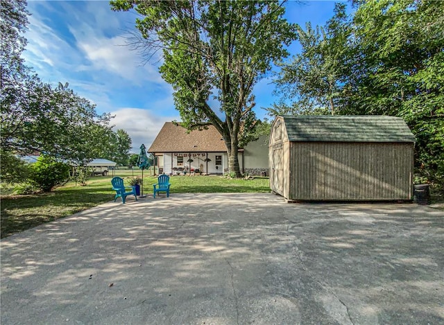 view of home's community featuring a lawn and a storage shed