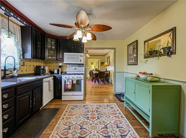 kitchen with ceiling fan, sink, white appliances, and light hardwood / wood-style floors