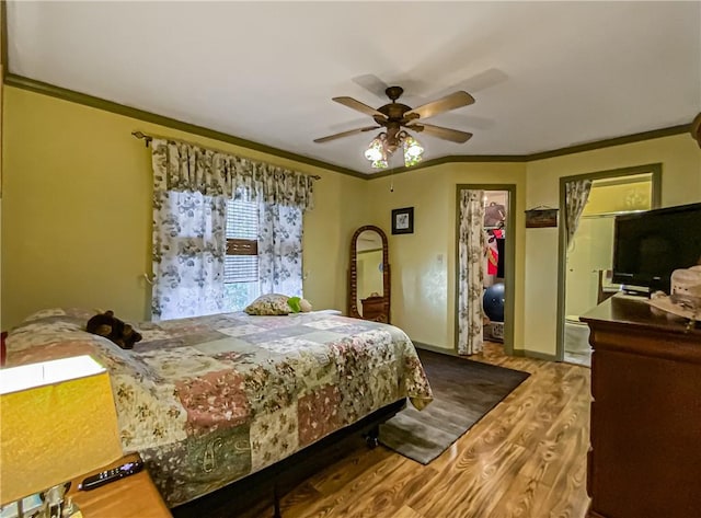 bedroom featuring hardwood / wood-style flooring, ornamental molding, ceiling fan, and a closet