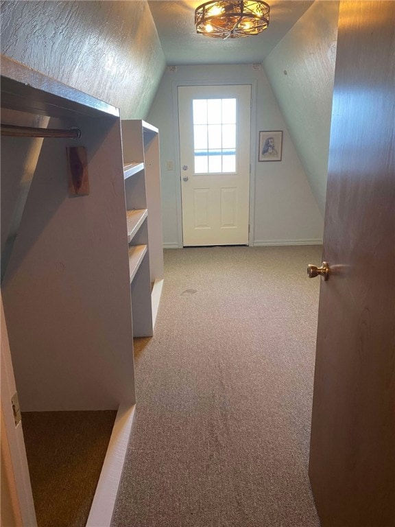 bonus room featuring lofted ceiling, light colored carpet, and a textured ceiling