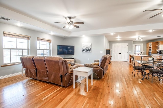 living room featuring ceiling fan and light hardwood / wood-style floors