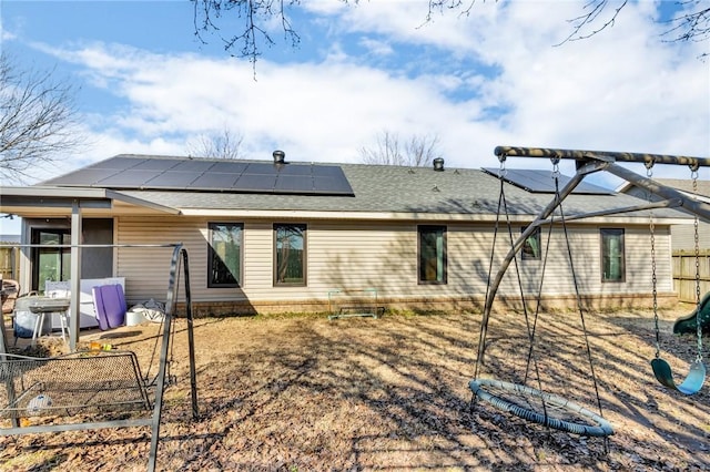 rear view of house featuring solar panels