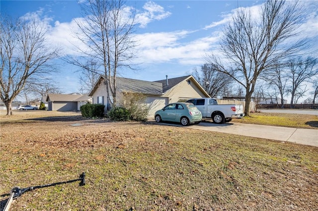 view of side of property with a garage and a lawn