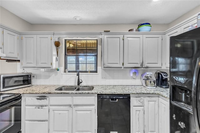 kitchen with tasteful backsplash, sink, white cabinets, and black appliances