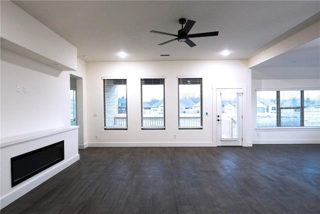 unfurnished living room with dark wood-type flooring and ceiling fan