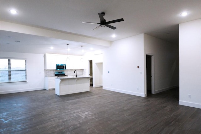 unfurnished living room with sink, dark wood-type flooring, and ceiling fan