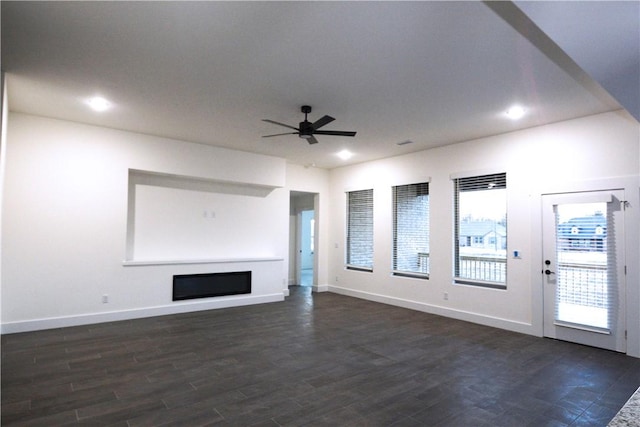 unfurnished living room with ceiling fan and dark hardwood / wood-style flooring