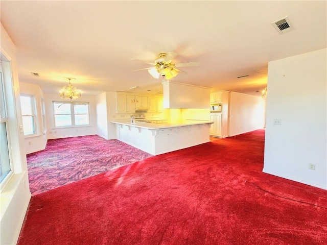 unfurnished living room featuring carpet floors and ceiling fan with notable chandelier