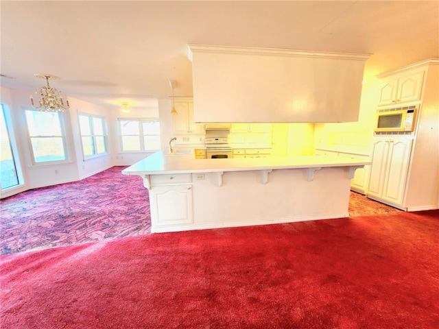 kitchen featuring light carpet, sink, white appliances, and a kitchen bar