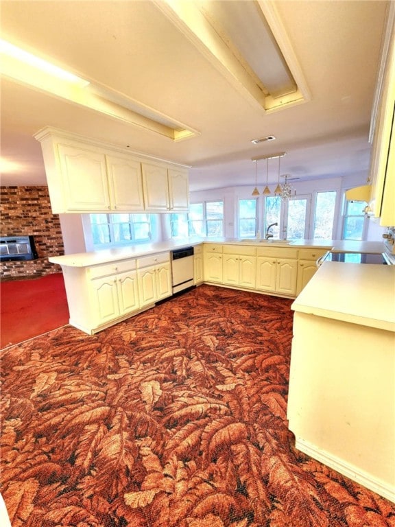 kitchen with pendant lighting, plenty of natural light, kitchen peninsula, and dishwasher