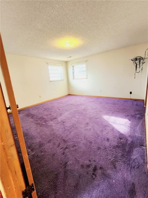 carpeted spare room with a textured ceiling