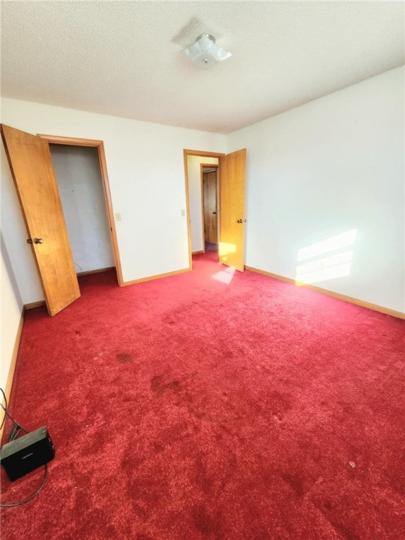 unfurnished bedroom with a textured ceiling and carpet